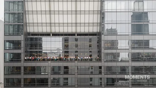 People Watching the Solar Eclipse from a Skyscraper Balcony